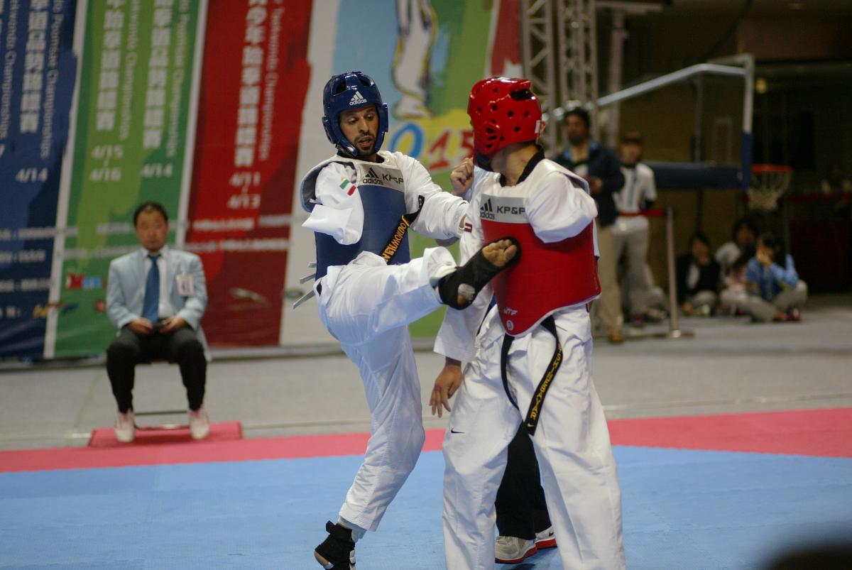 Para-Taekwondo A para-taekwondo athlete does a jump kick to his opponent.