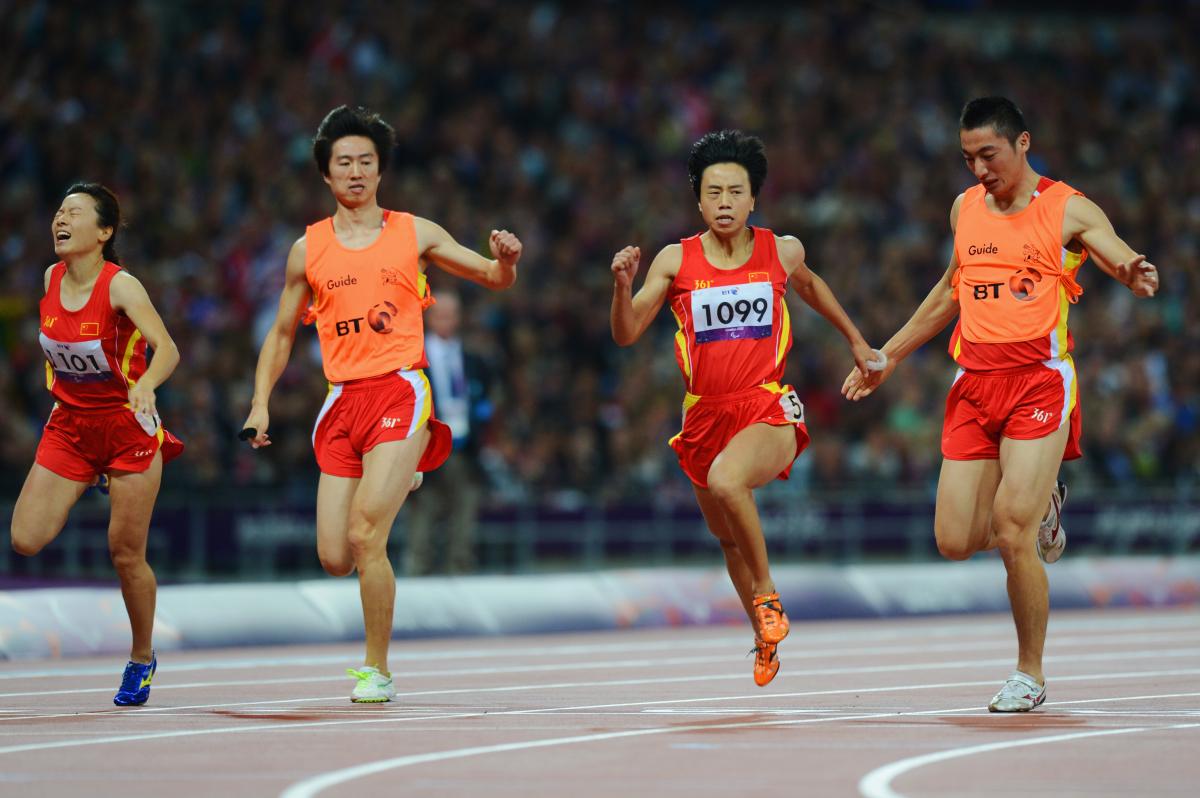 China's Guohua Zhou and her guide Jie Lie cross the line first to win gold ahead of teammates and bronze medalists Daqing Zhou of China and her guide Hui Zhang in the women's 100m T12 Final at the London 2012 Paralympic Games.