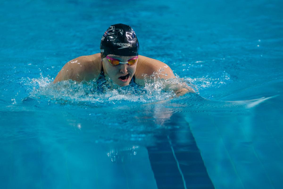 Female swimmer takes a breath between strokes