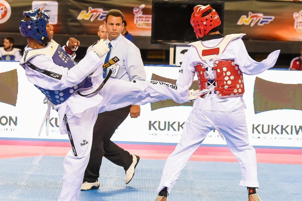 A taekwondo athlete kicks another taekwondo athlete