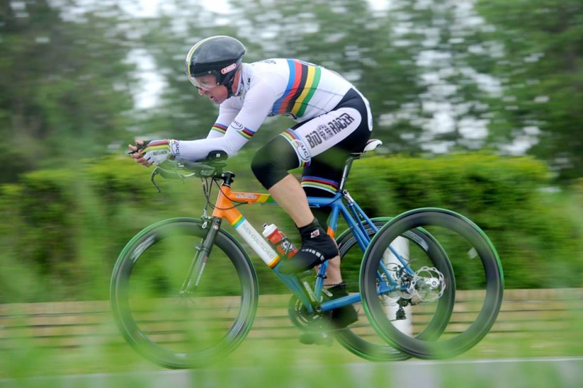 Man on tricycle racing on the road