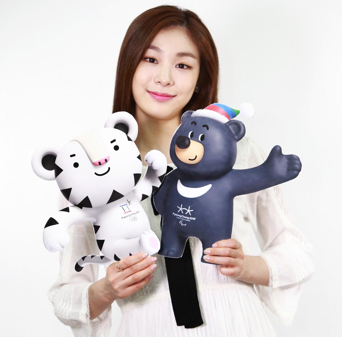 Asiatic woman holding two images of tiger and bear mascot