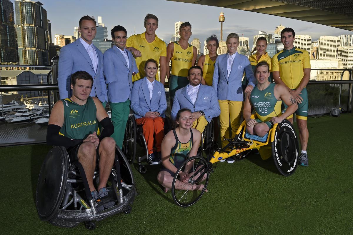 A group of 12 paralympians wearing the new green and yellow uniforms. 