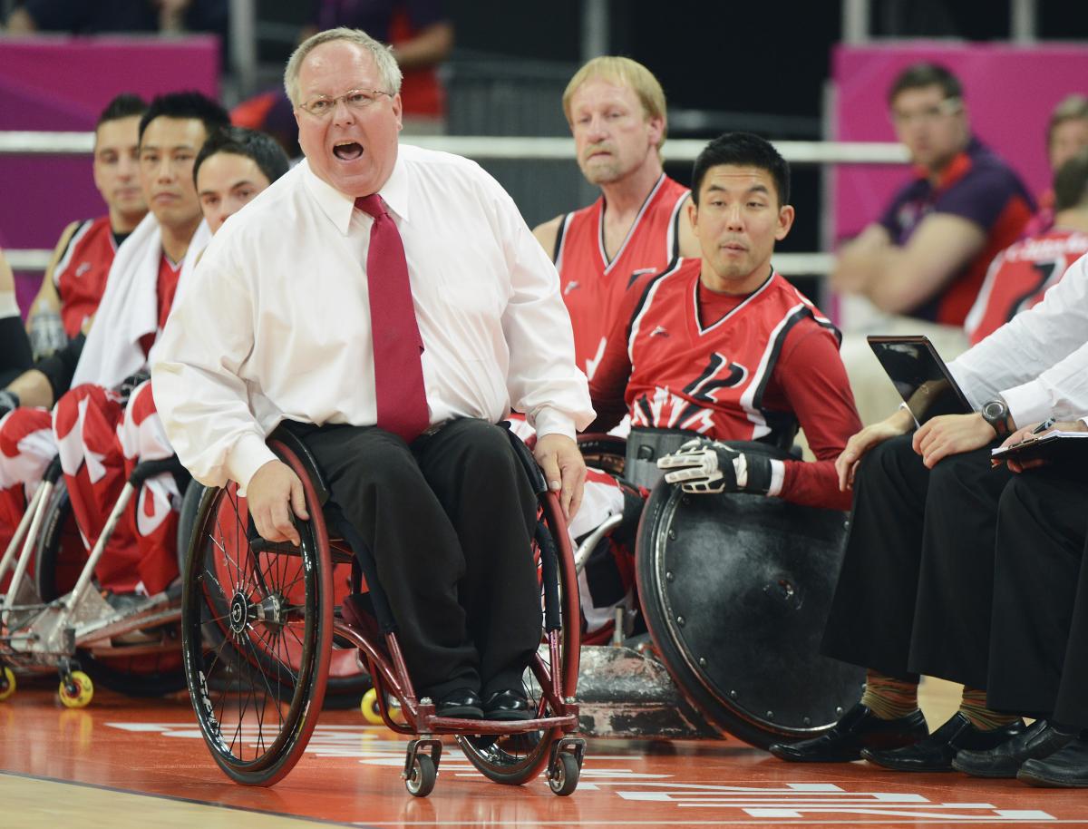 Wheelchair rugby coach in wheelchair yells instructions 