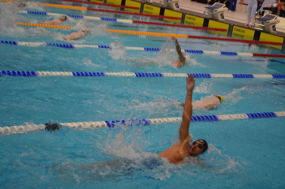 Swimmers compete in a backstroke event. 
