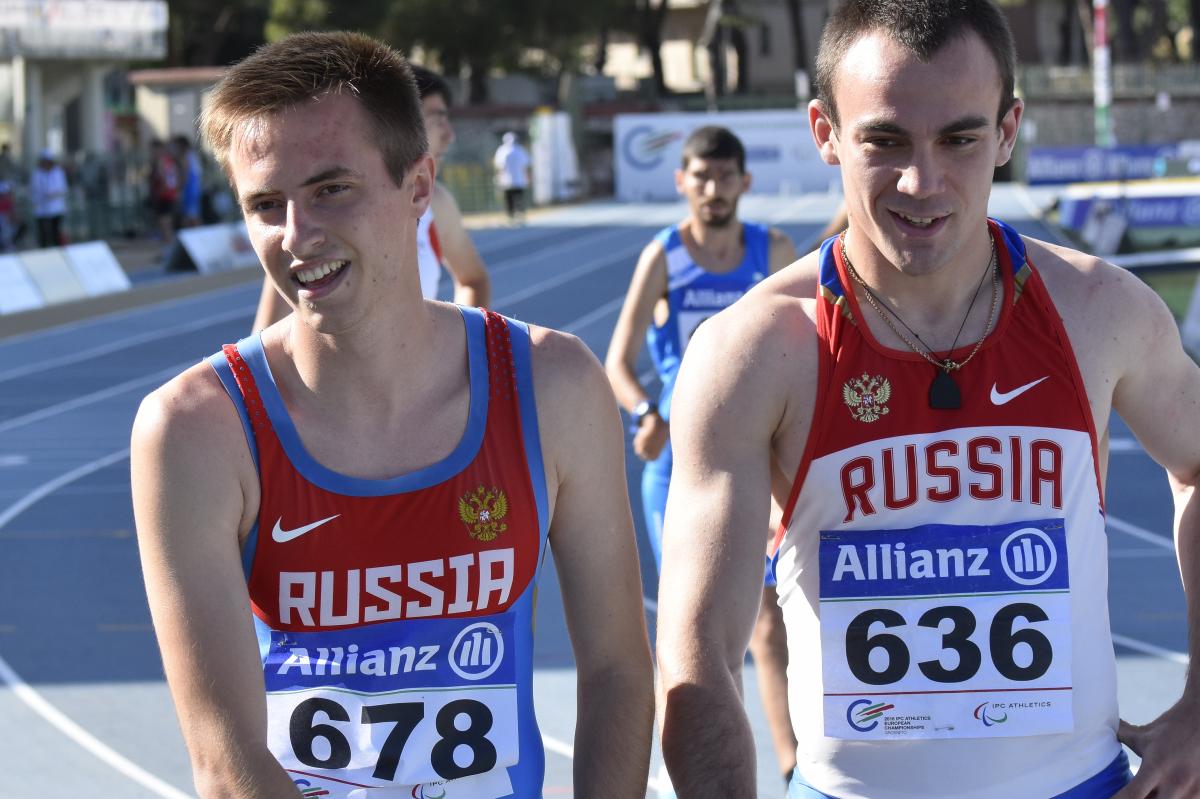 Upper bodies of two men in Russian jerseays on a track