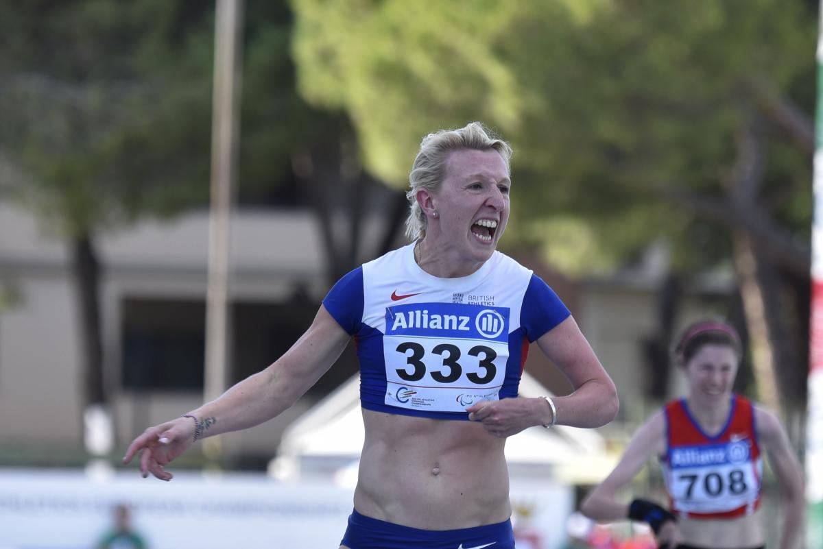Woman in running shirt crossing the finish 