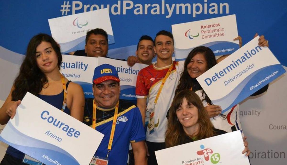 ProudParalympian Toronto 2015 Group picture of four people, smiling and holding signs with 'ProudParalympian'