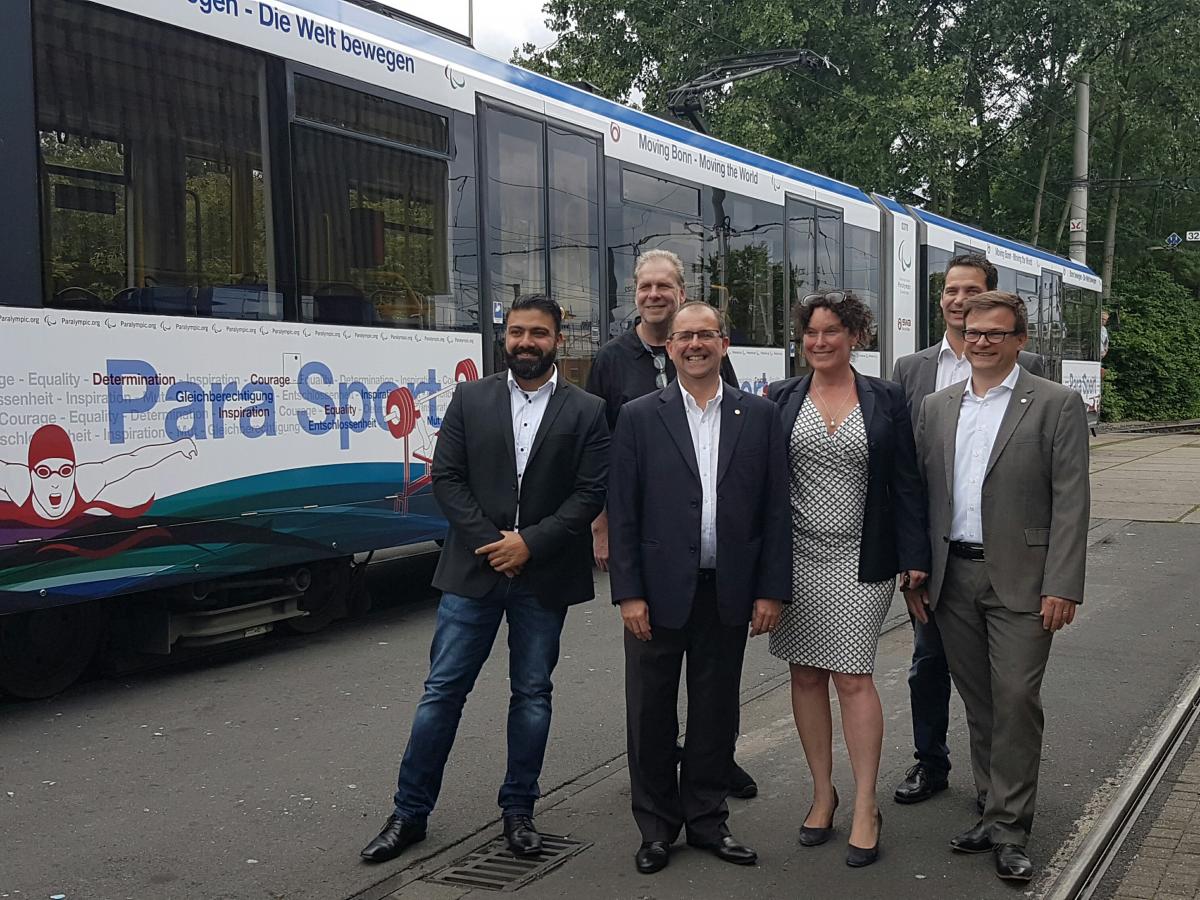 Five people standing in front of a tram in IPC design