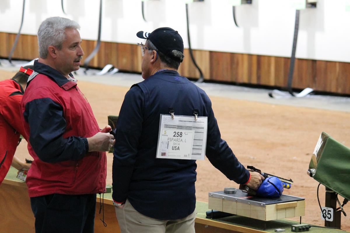 Two men in a shooting range, talking