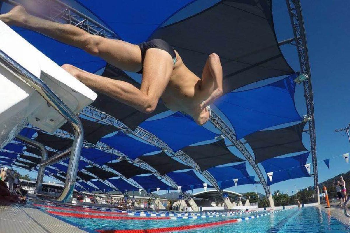 Swimmer jumping from the block into the water