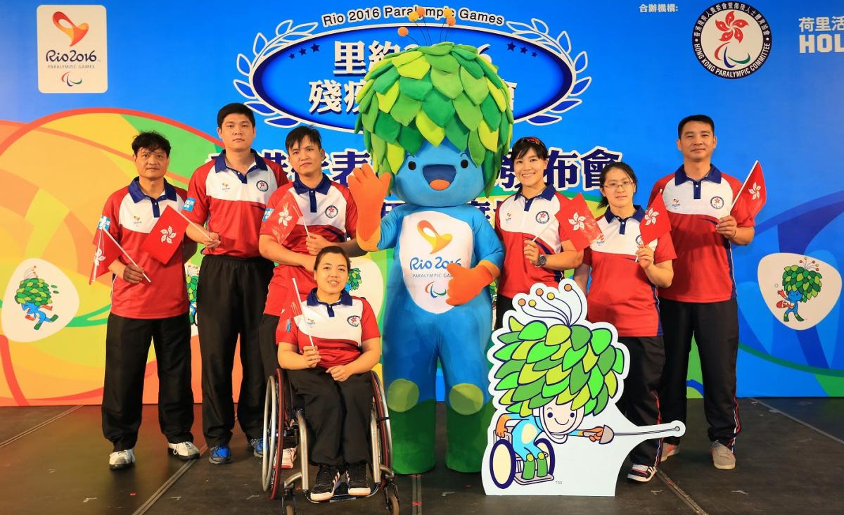 Seven athletes posing with Rio 2016 Tom mascot