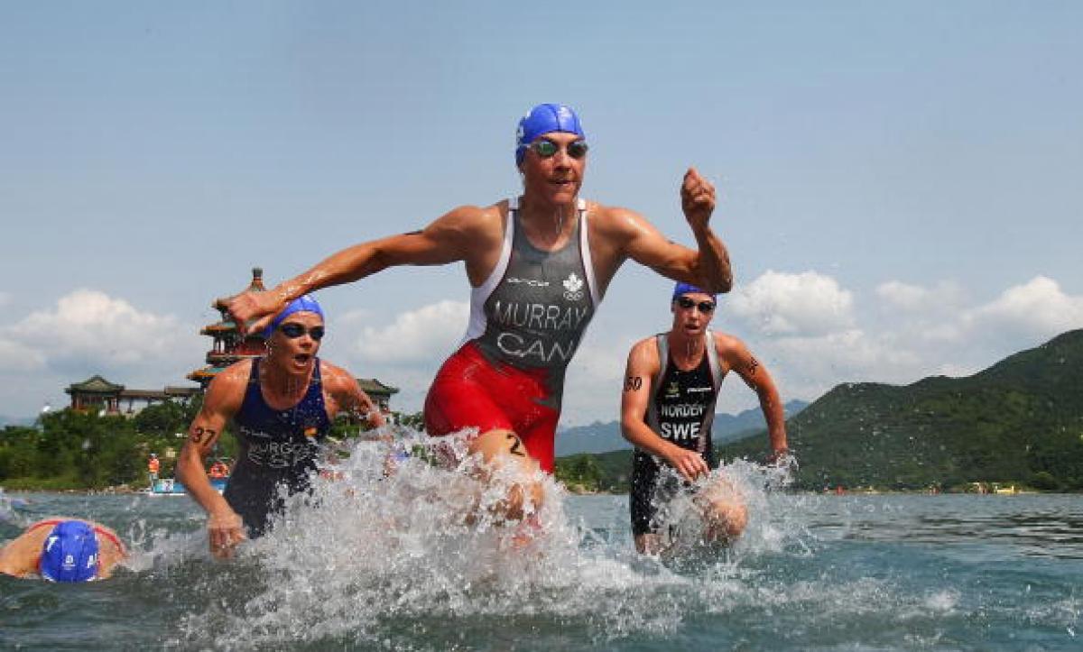 Carolyn Murray - Canada's former able-bodied triathlete Women in swim suite leaving the water.