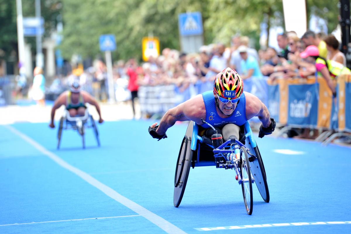 Man in racing wheelchair outside on a street