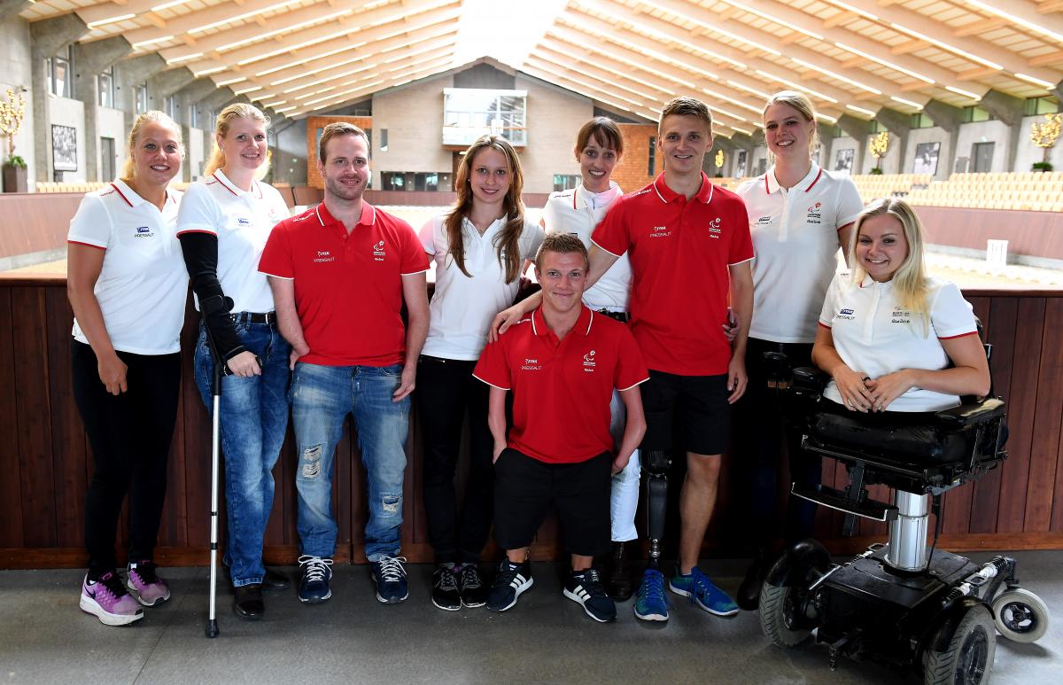 Fifteen Danish Para athletes pose for a photo wearing the red and white Danish colours.