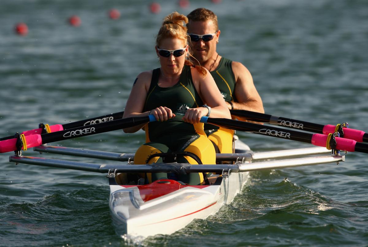 Man male and female rower on boat in the water.