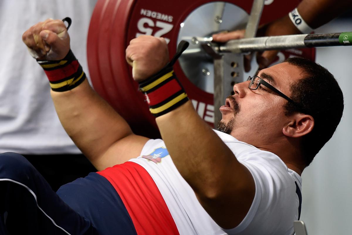 Juan Carlos Garrido - Chile - Powerlifting Chilean powerlifter Juan Carlos Garrido is on the bench and raises his hands celebrating his win.