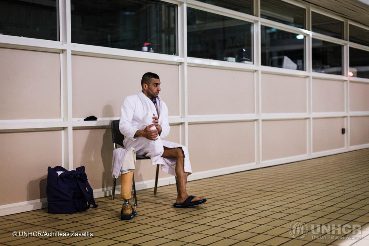 Man with amputated leg sitting close to swimming pool