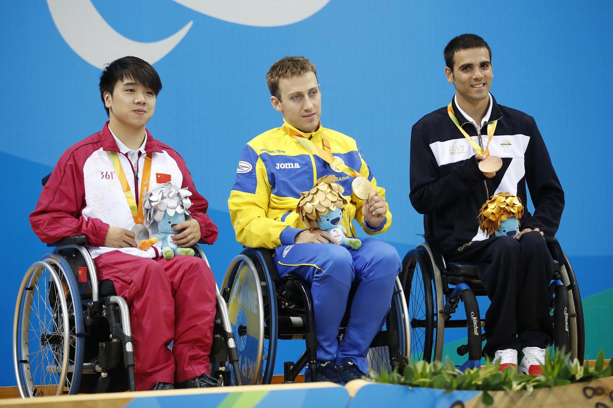 Three medallists in wheelchairs on the podium