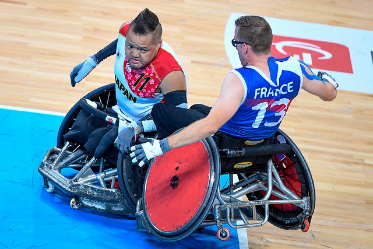Two wheelchair rugby players crashing into each other