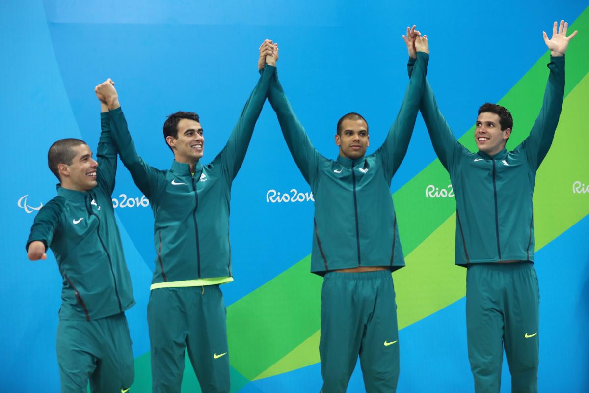 Four Brazilian swimmers on a podium celebrating