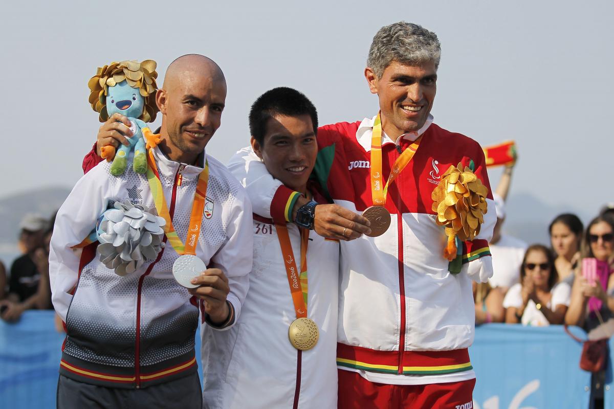 Three men on the podium, smiling