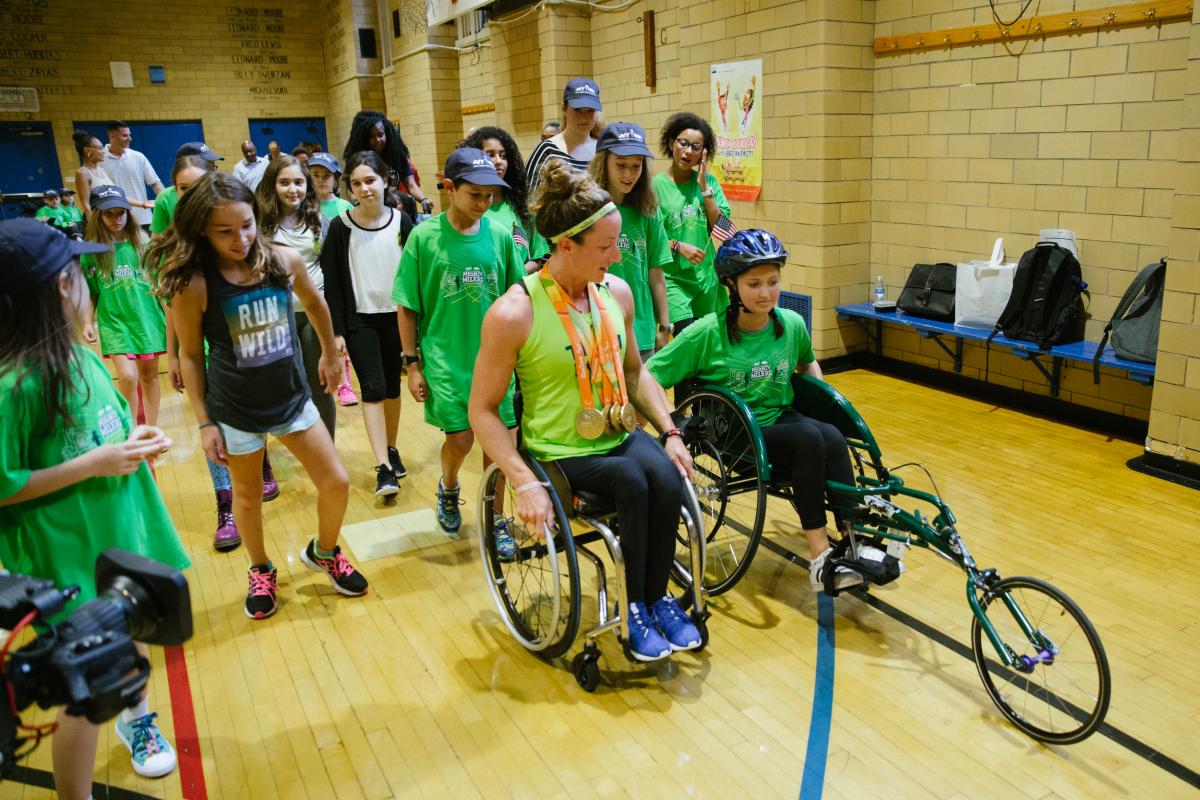Tatyana McFadden NYRR An athletes shows a young girl how to use a racing wheelchair