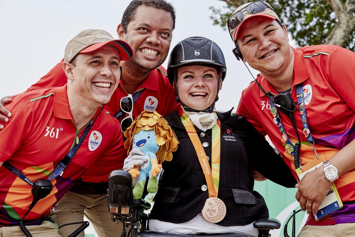 Stinna Tange Kaastrup celebrating her gold medal with volunteers.