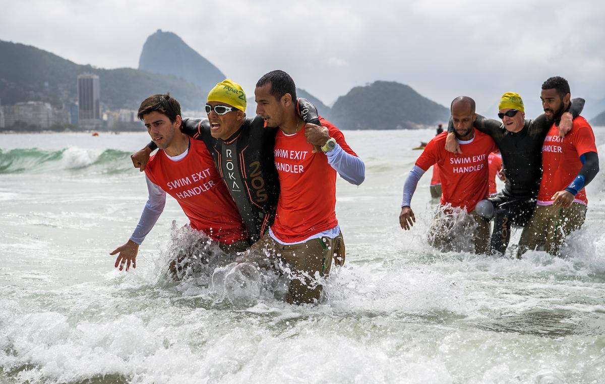 Mohamed Lahna MAR (left) and Stephane Bahier FRA are aided out of the water during the Men's PT2 Triathlon competition at Fort Copacabana.