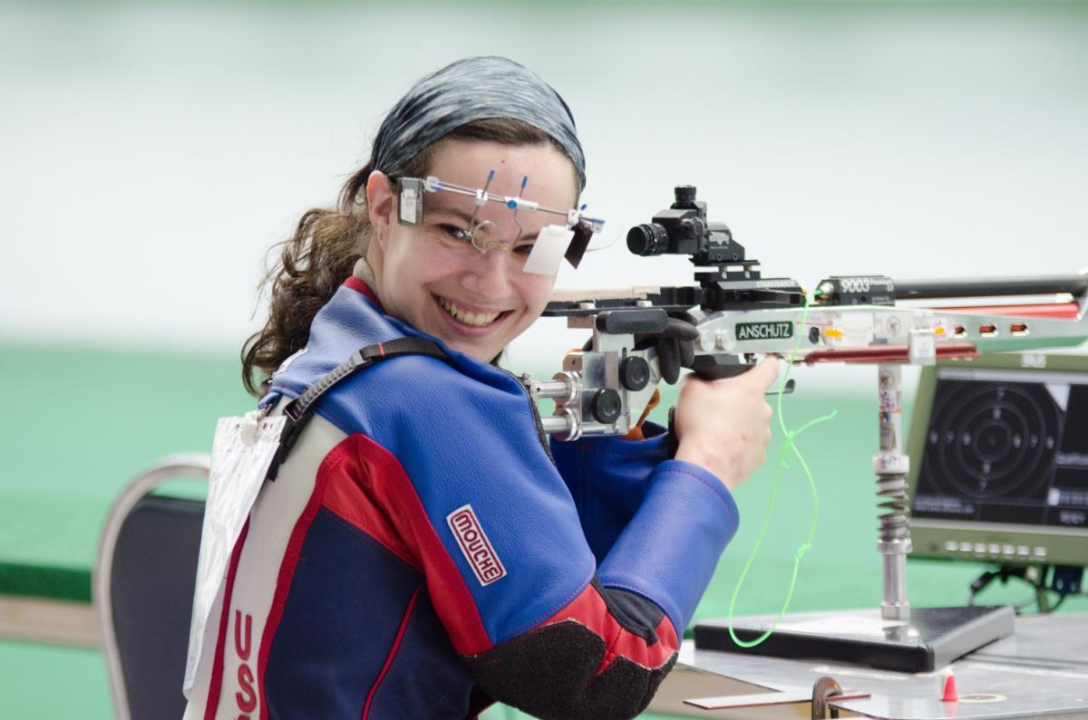 USA’s McKenna Dahl at the 2016 IPC Shooting World Cup Bangkok, Thailand Woman in shooting range, looking back over her shoulder, smiling