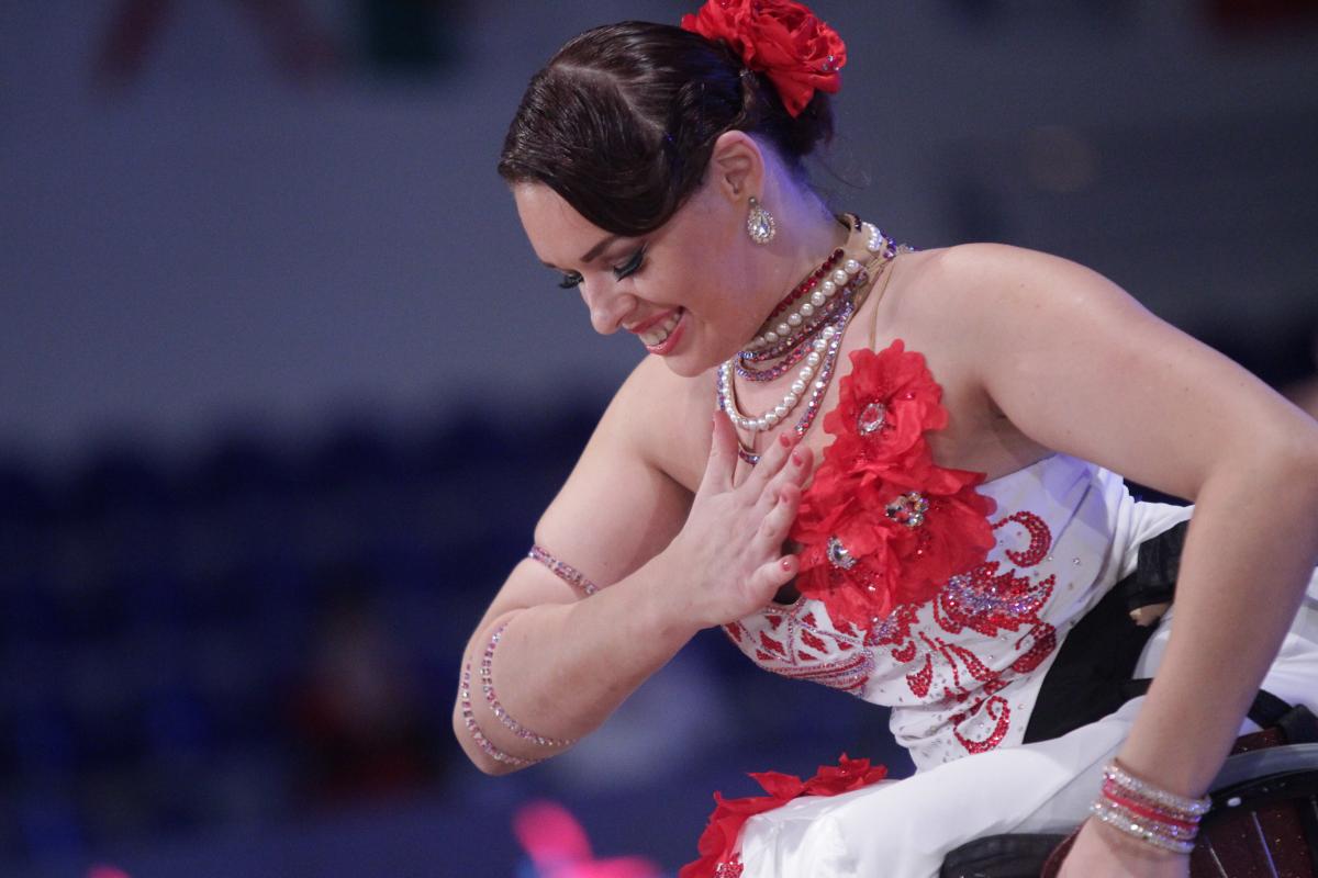 Woman wheelchair dancer bows to the audience