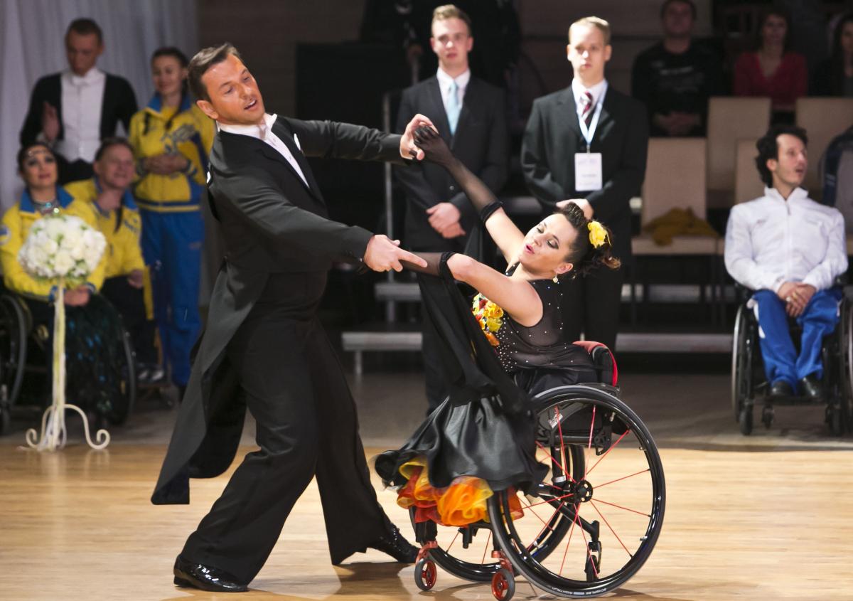 A woman in wheelchair dances with a man standing up