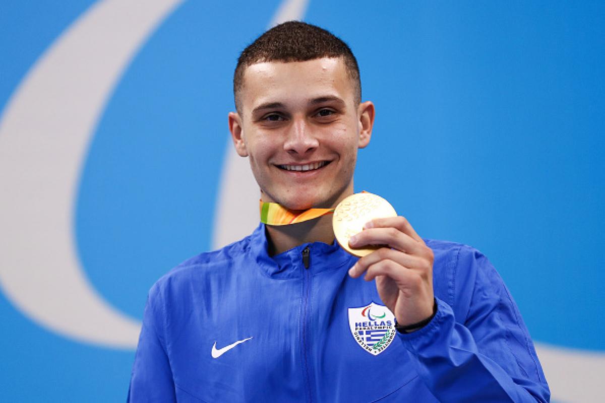 Man on podium showing his medal