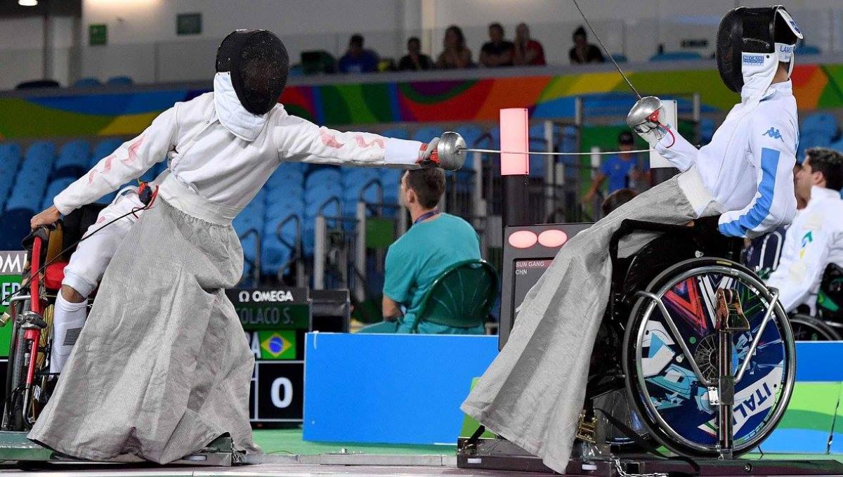 Two men in wheelchairs fencing