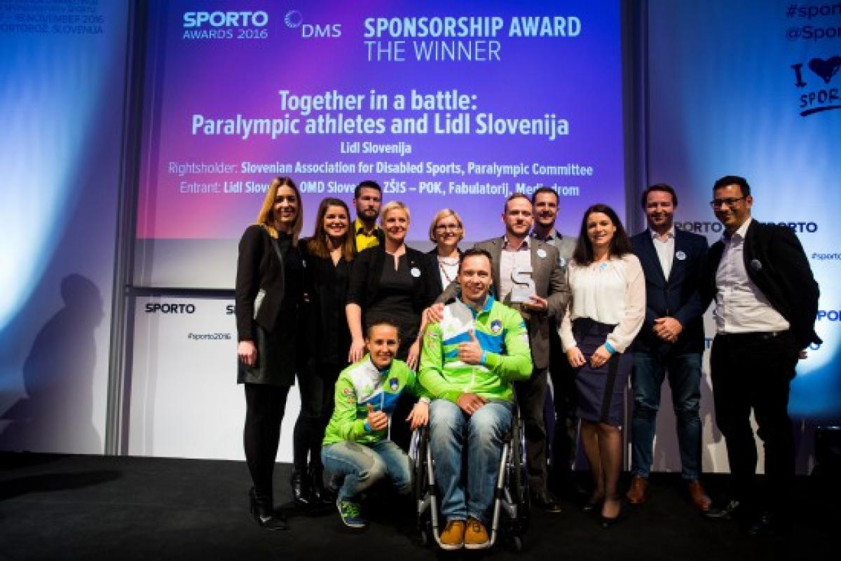 Group of people pose for picture on stage