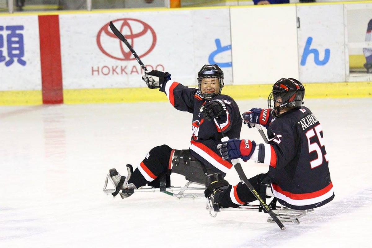 Two ice sledge hockey players on the ice