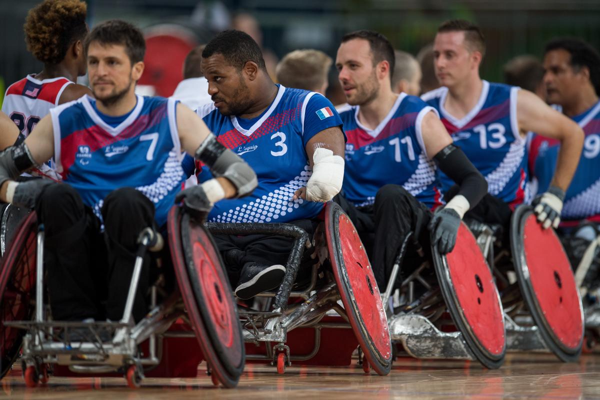 Men in wheelchairs form a line