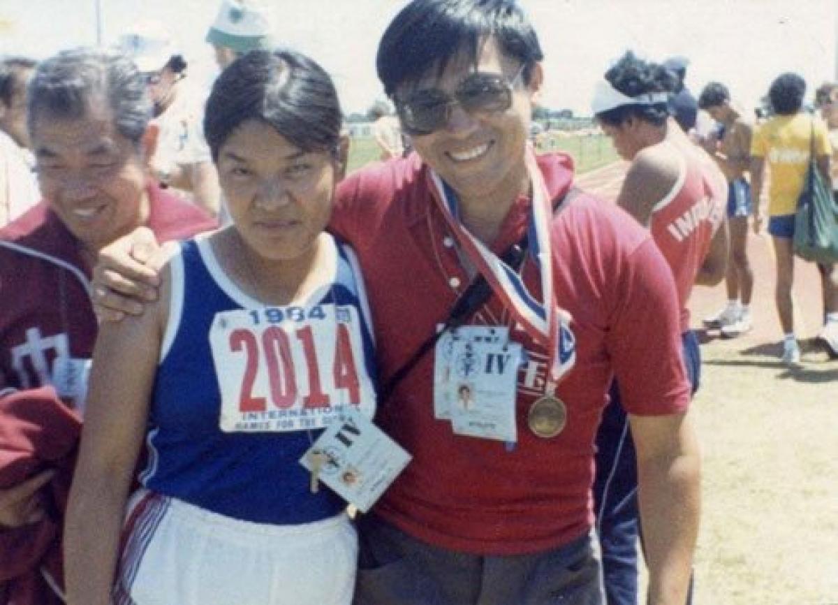 Two people posing for a photo in track clothes