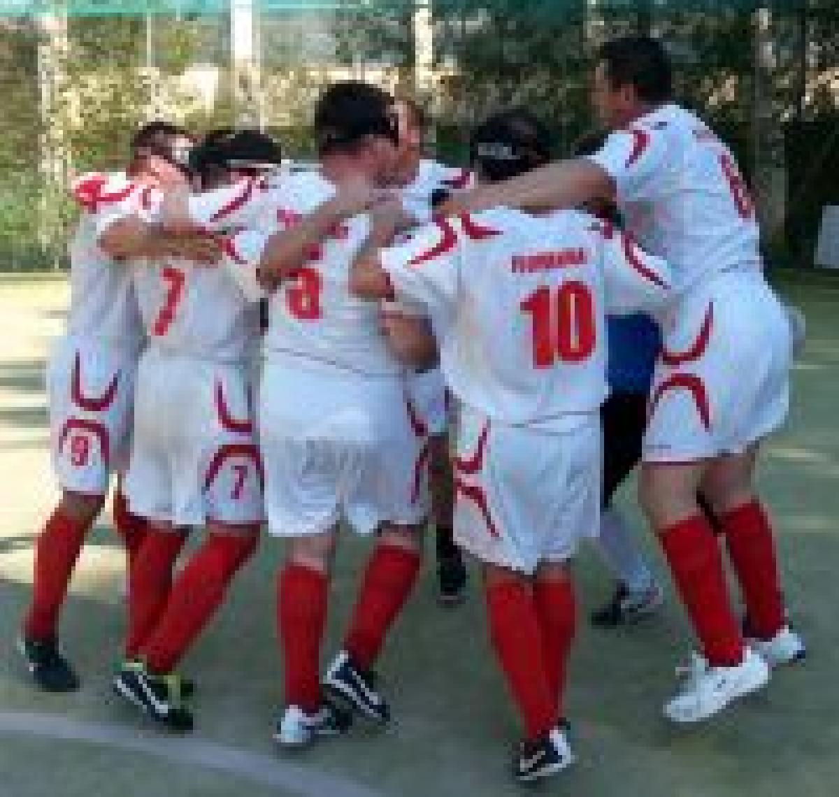 Blindfolded men in jerseys celebrating