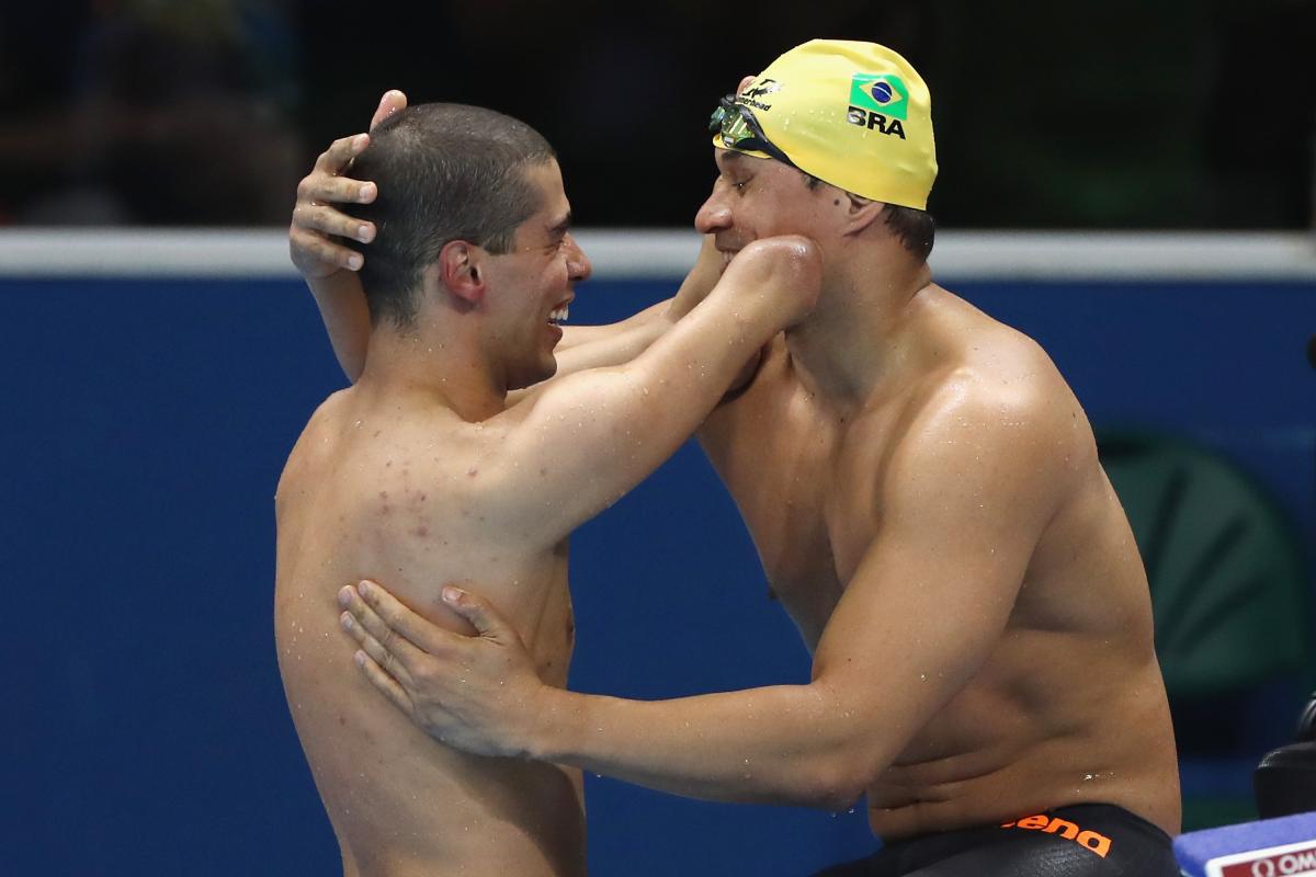 Two Para swimmers embrace after a race