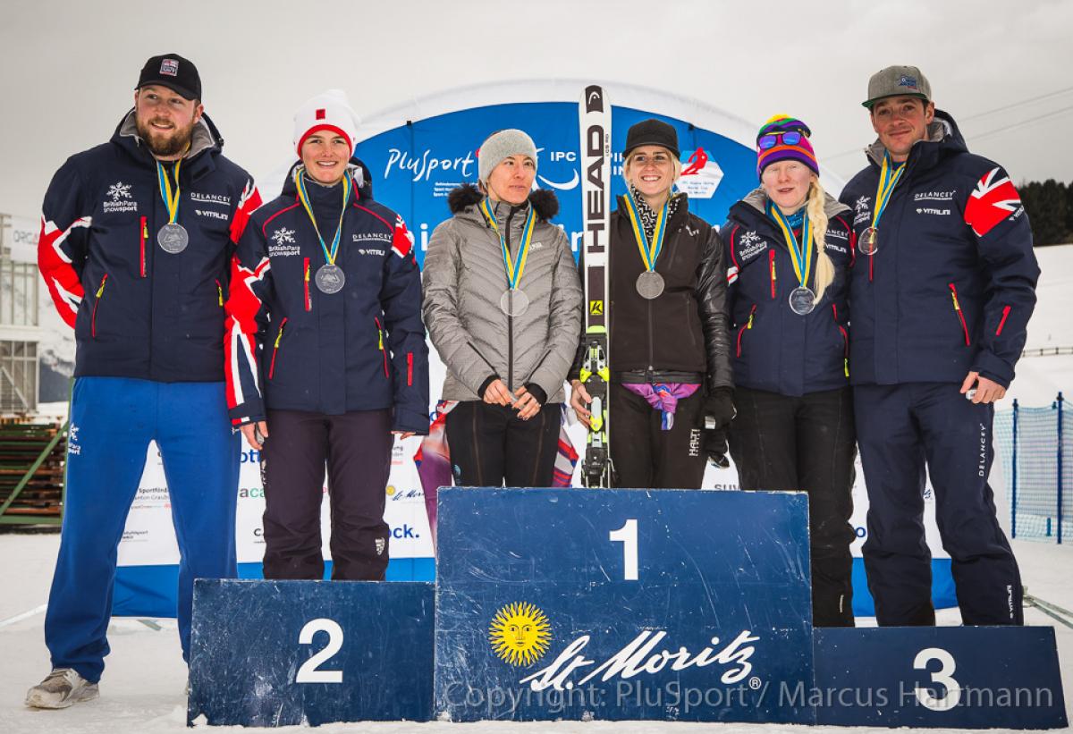 Henrieta Farkasova Millie Knight Kelly Gallagher - alpine skiing Three female alpine skiers and their guides standing on the podium