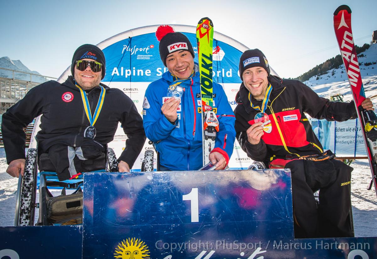 Three sit skiers hold their medals