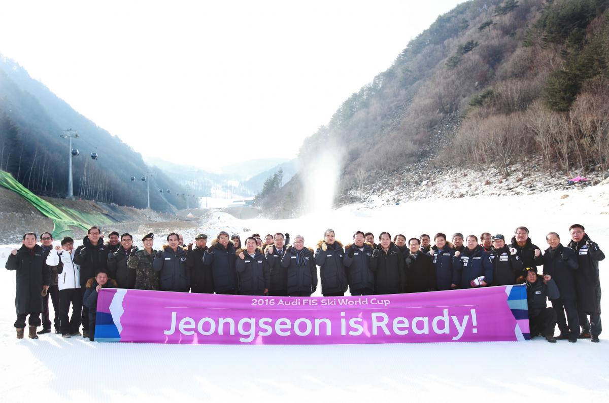 Group of people pose in front of slopes