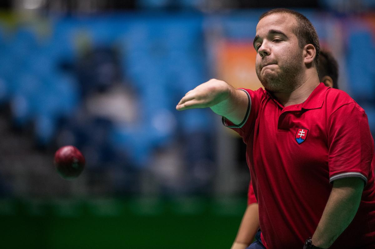 Upper body of man throwing a red ball