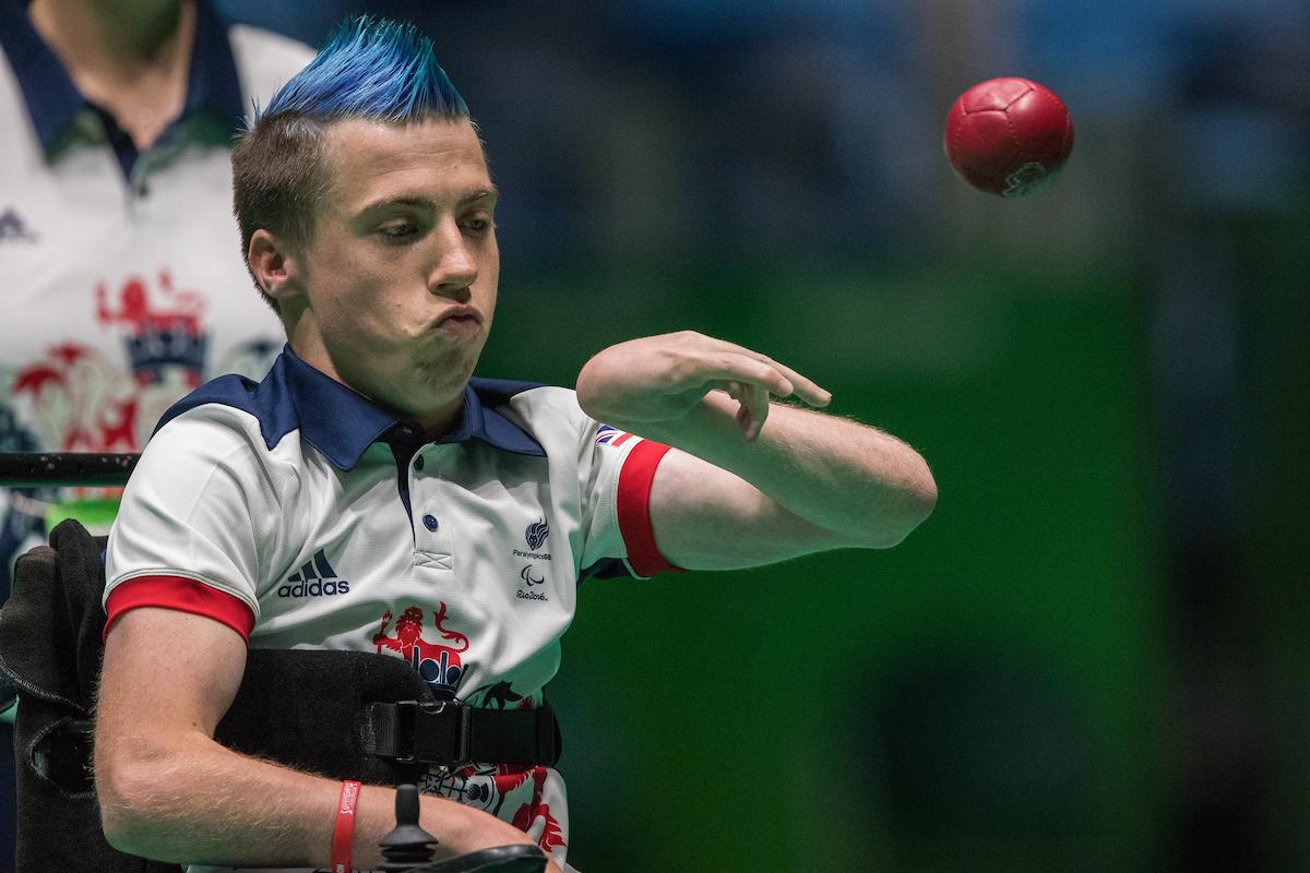 Upper body of man throwing a red ball