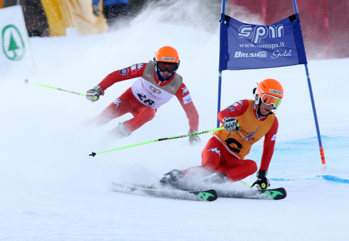 A Para alpine skier and guide make a turn round a gate.