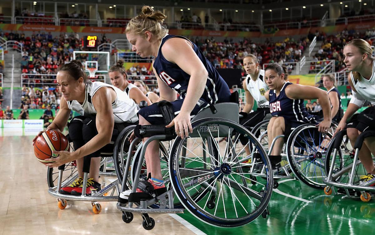 Two women in wheelchairs on the basketball court