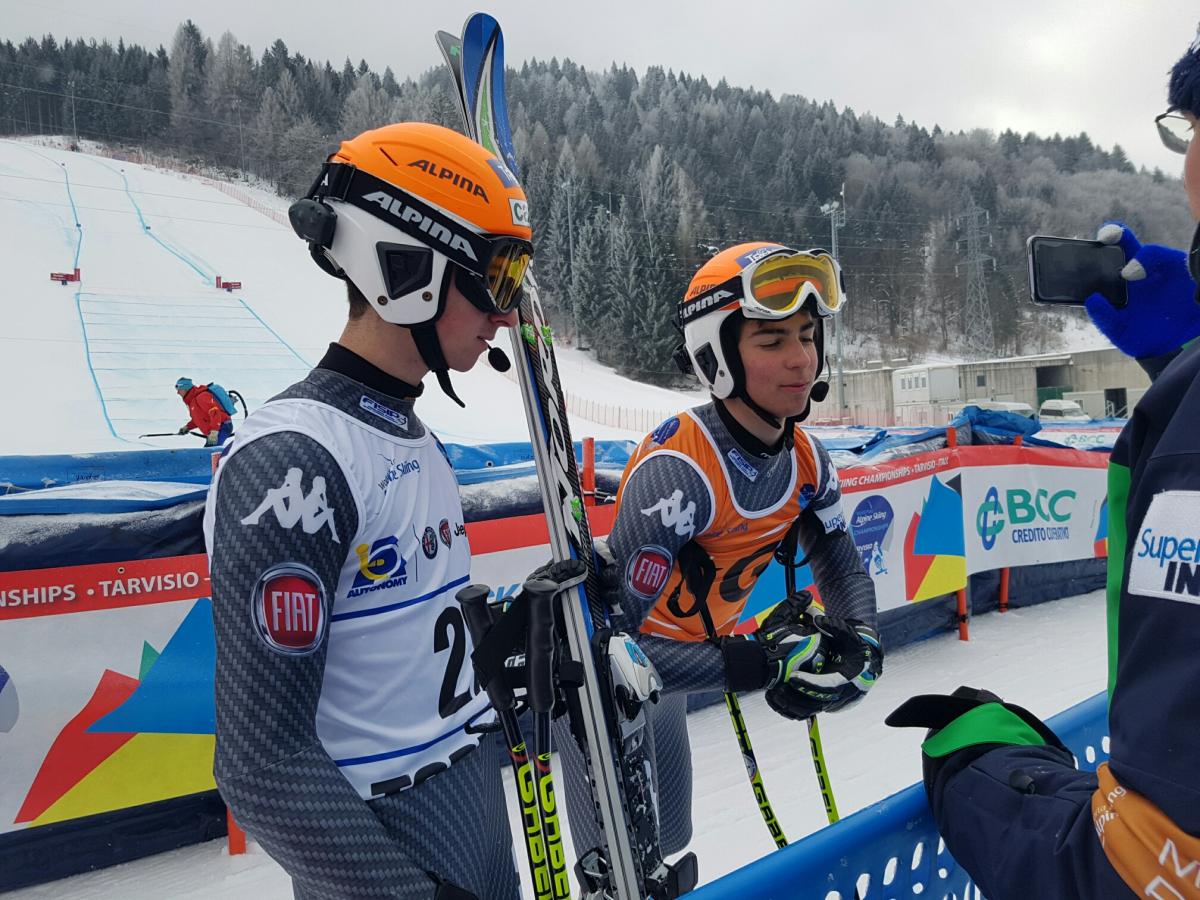 A visually impaired skier and guide in the mixed zone