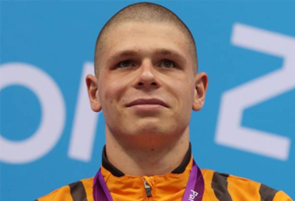 A picture of a man with a gold medal around his neck during a medal ceremony