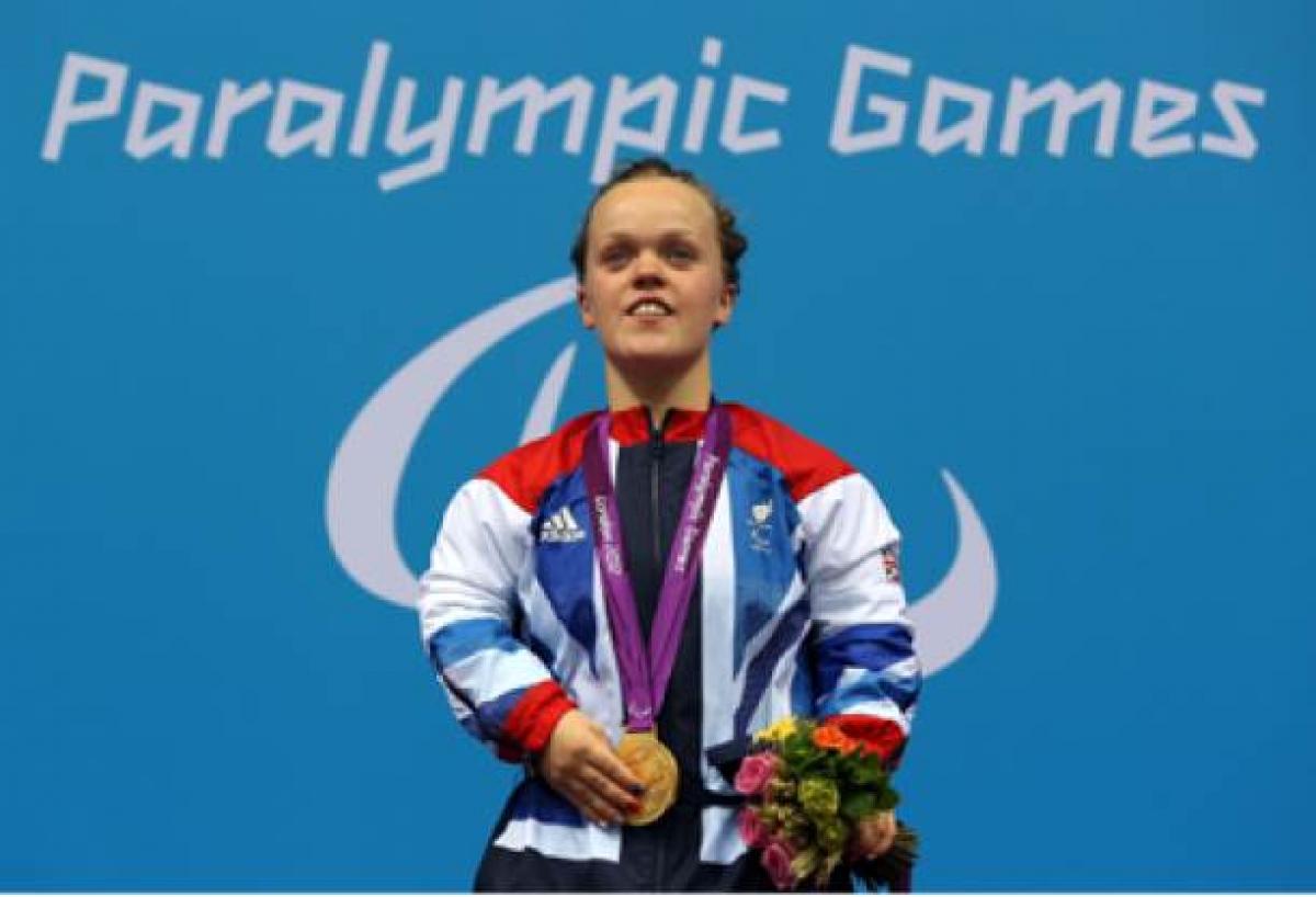 A picture of a woman with a gold medal around her neck